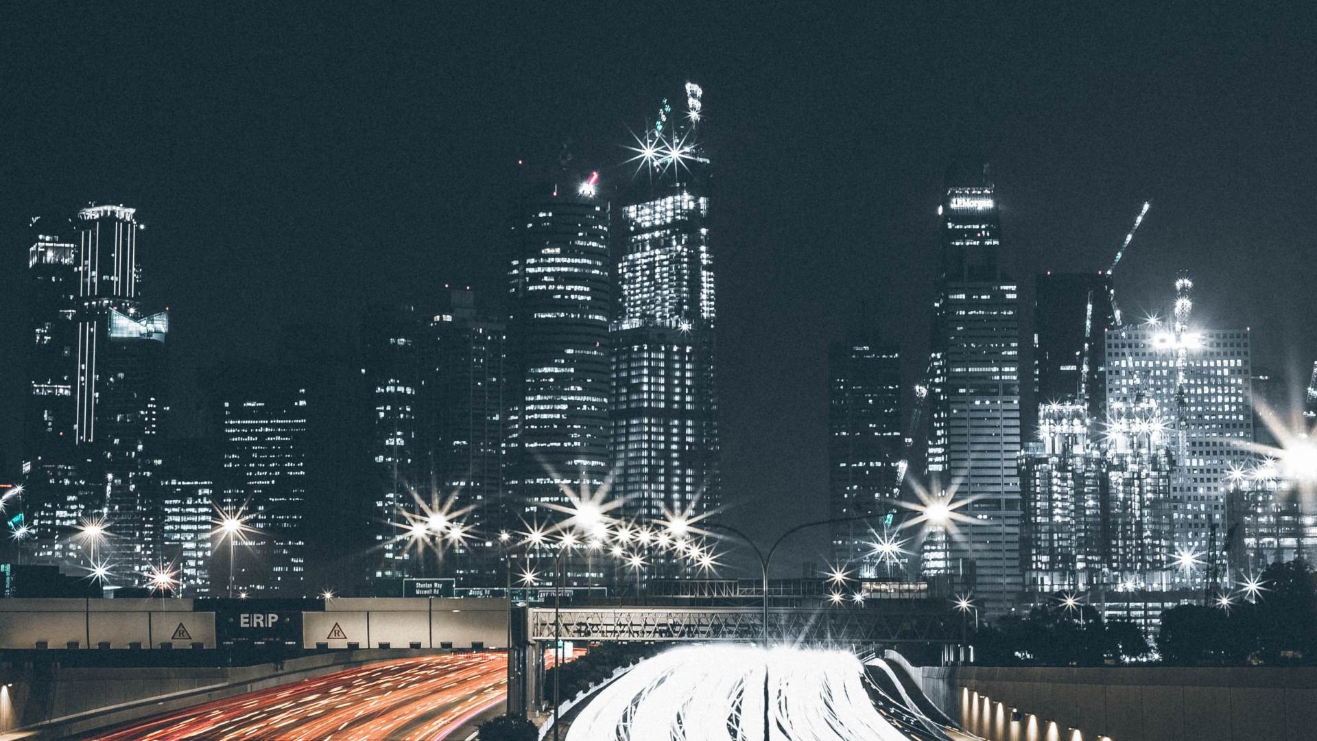 Skyline at night with lights and car headlights