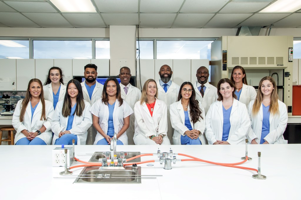 SMU Veterinary Faculty and Students pose for a group picture in microbiology lab