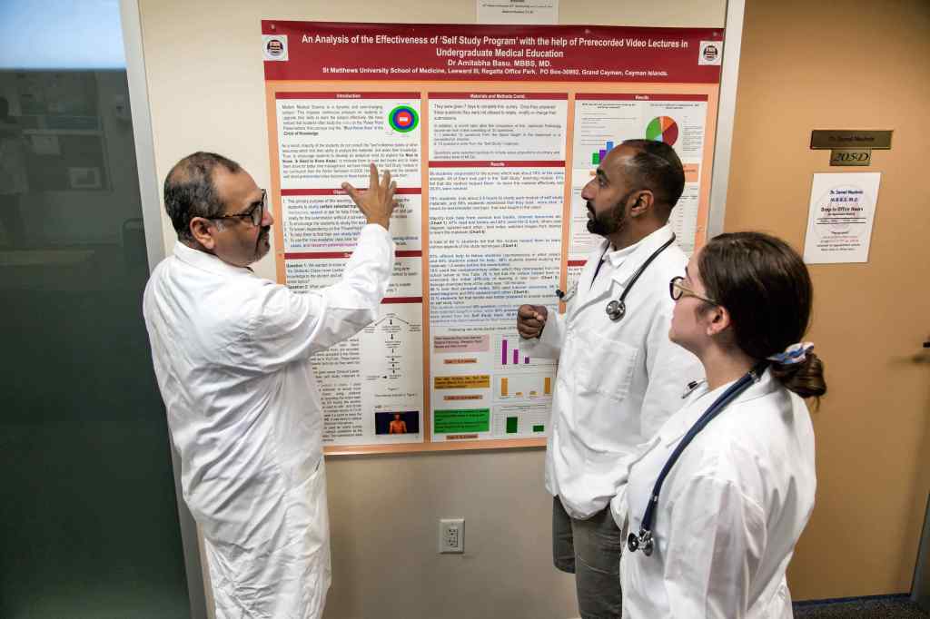 Dr. Basu, Dean of SMU Medical School provides feedback to students on their research project