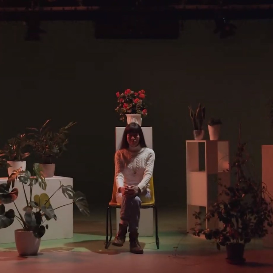 Woman sitting in a studio surrounded by plants